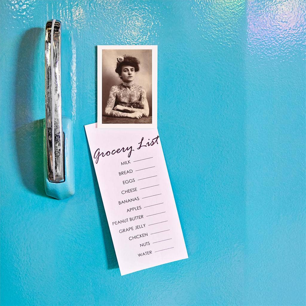 Grocery list and vintage photo attached to a blue refrigerator with a clip.
