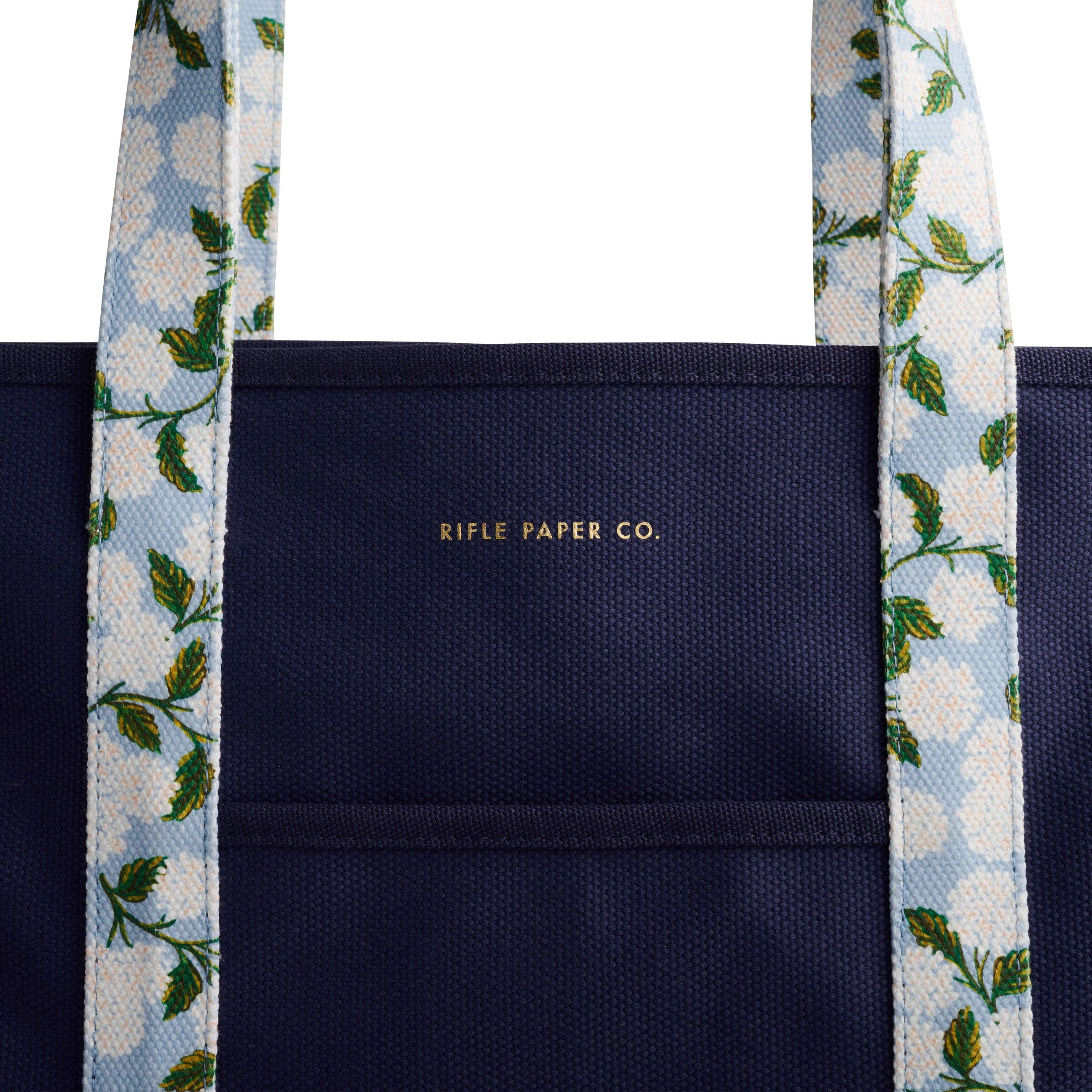 Navy tote bag with floral straps featuring 'Rifle Paper Co.' branding.