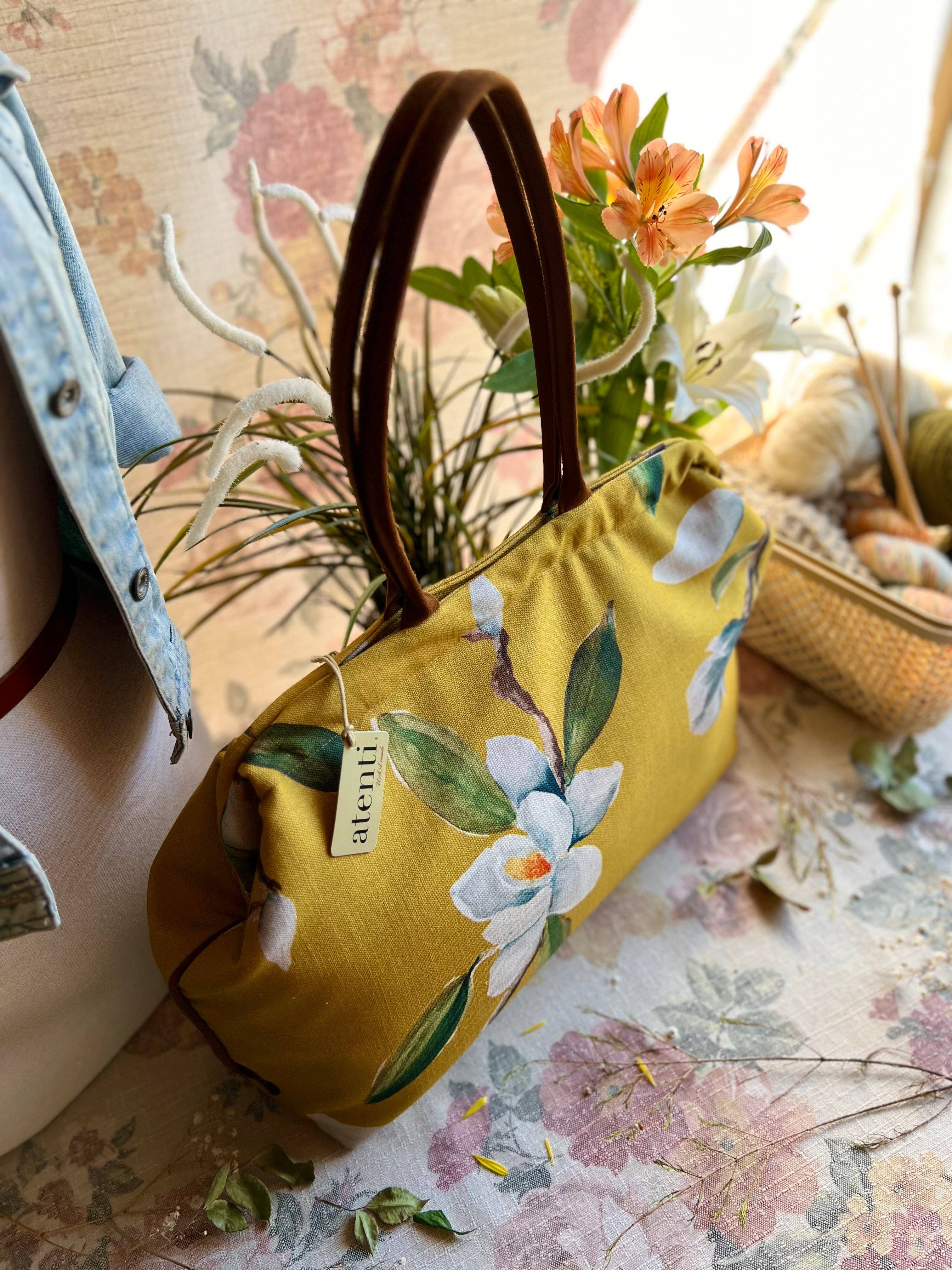 Floral-patterned handbag on a floral surface with a tag