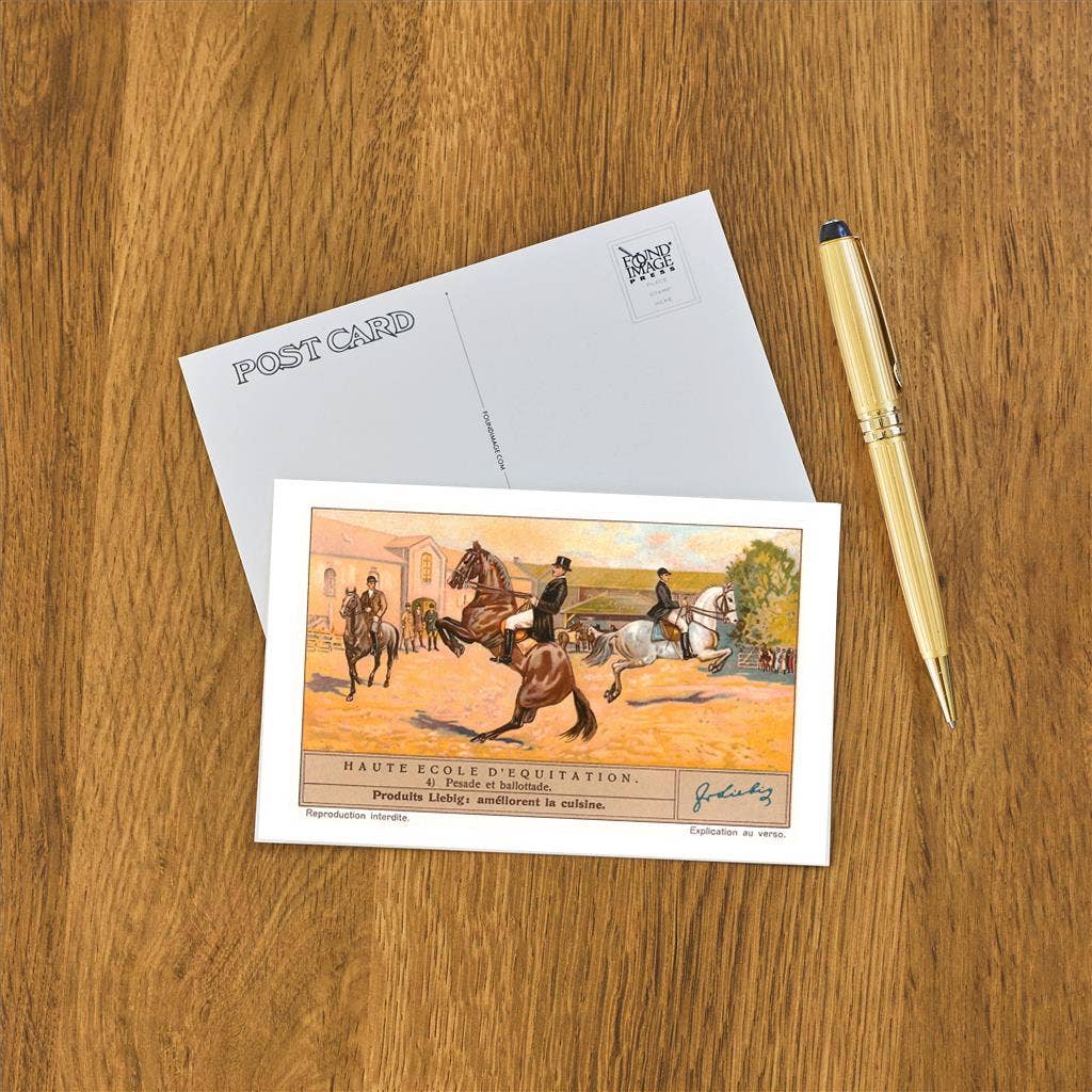 Postcard with horseback riding illustration on a wooden surface with a pen.