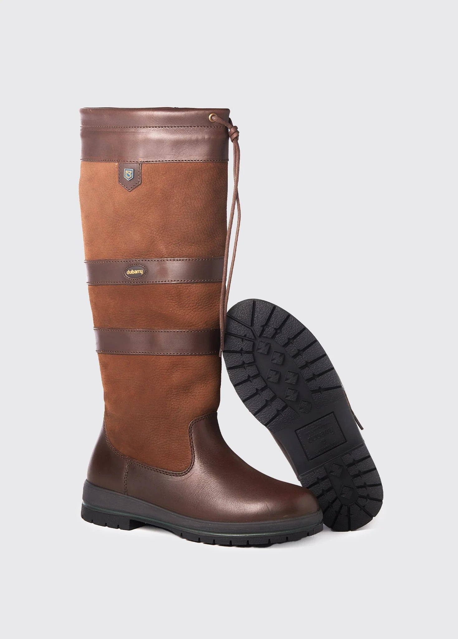 Brown leather boot with a black sole on a light gray background