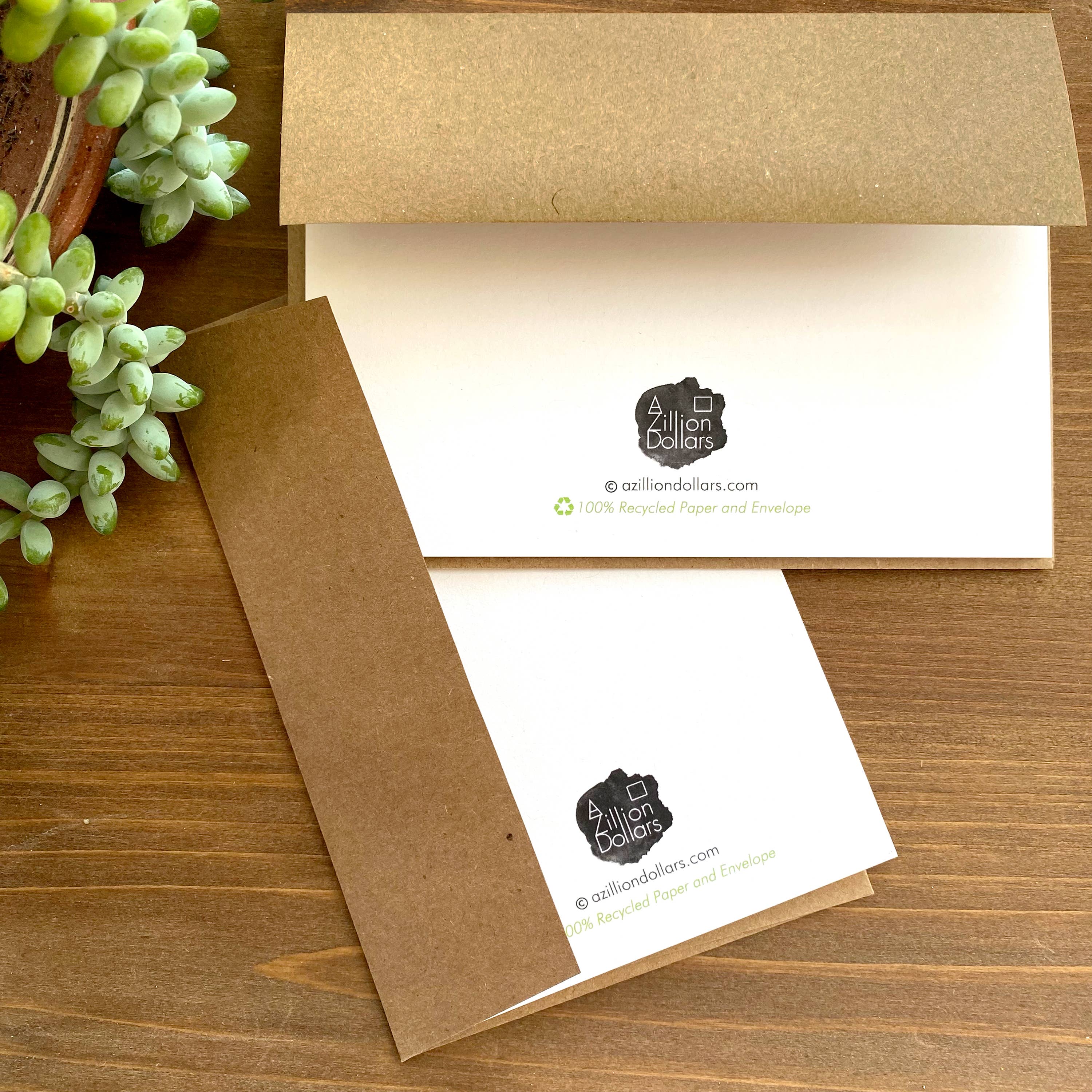 Kraft paper envelopes with a brand logo on a wooden surface with a plant.