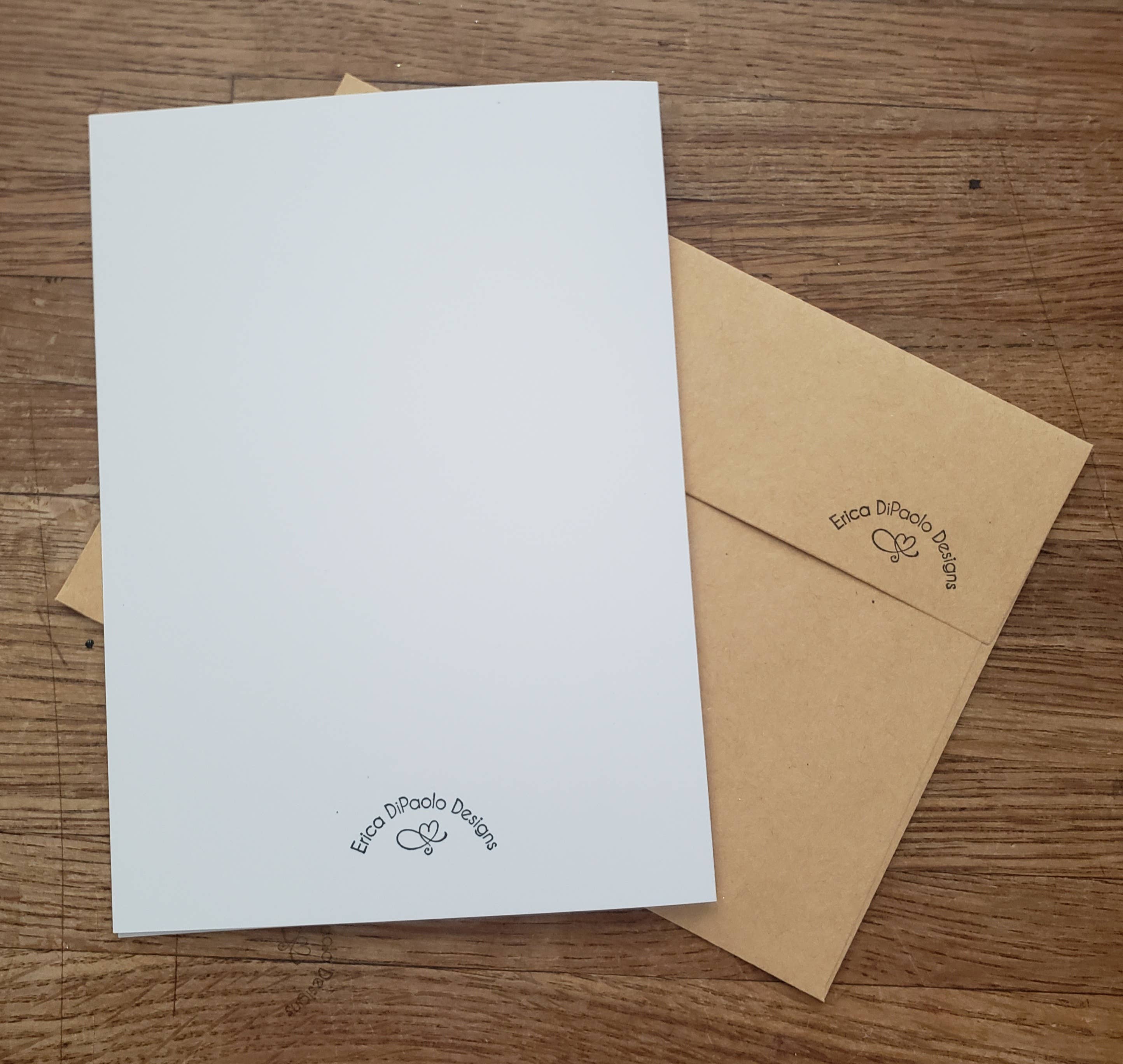 White card and brown envelope with 'Erica DiPaolo Designs' logo on a wooden surface
