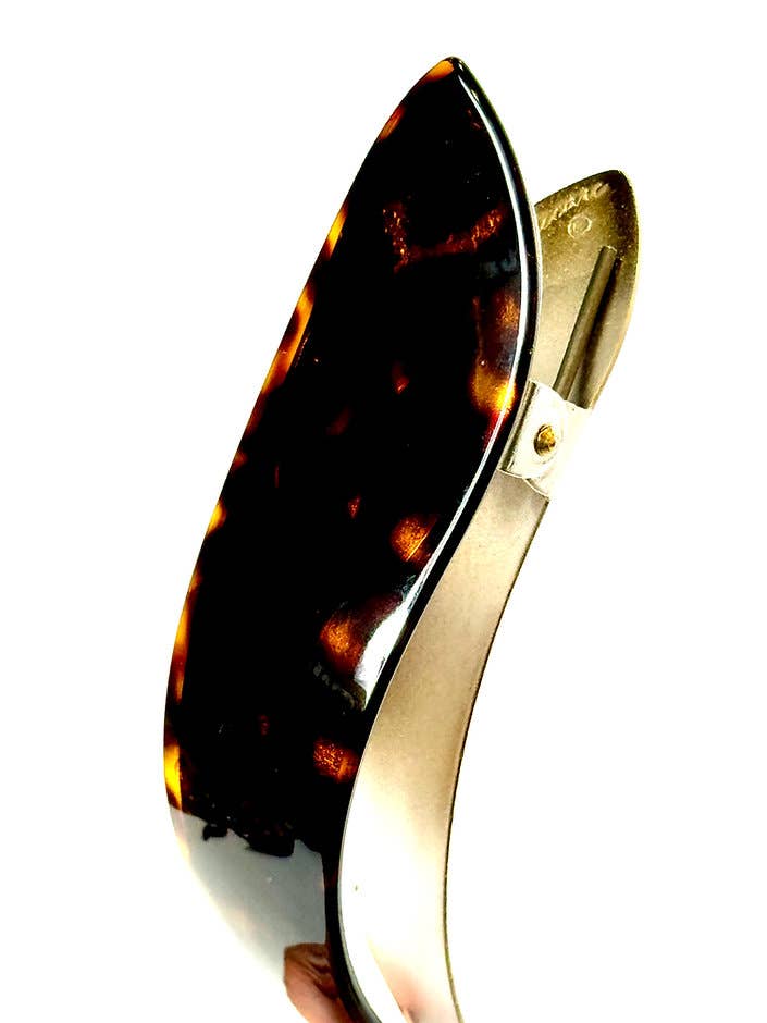 Tortoiseshell and gold hair clip on a white background