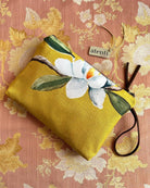 Yellow pouch with floral design on a floral patterned background