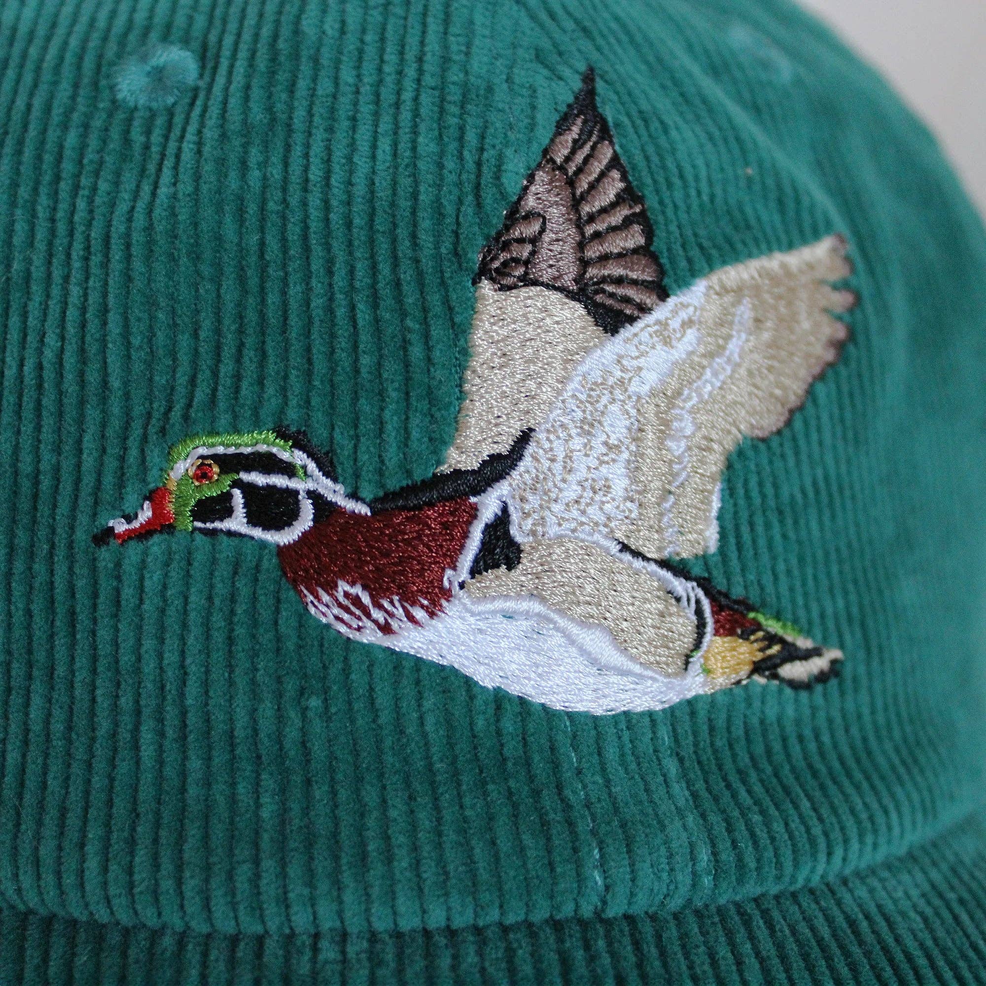 Green cap with an embroidered duck design on a blurred background