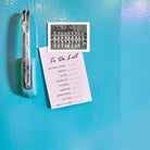 To-do list on a refrigerator with a photo clip and black and white photo of people in uniform.