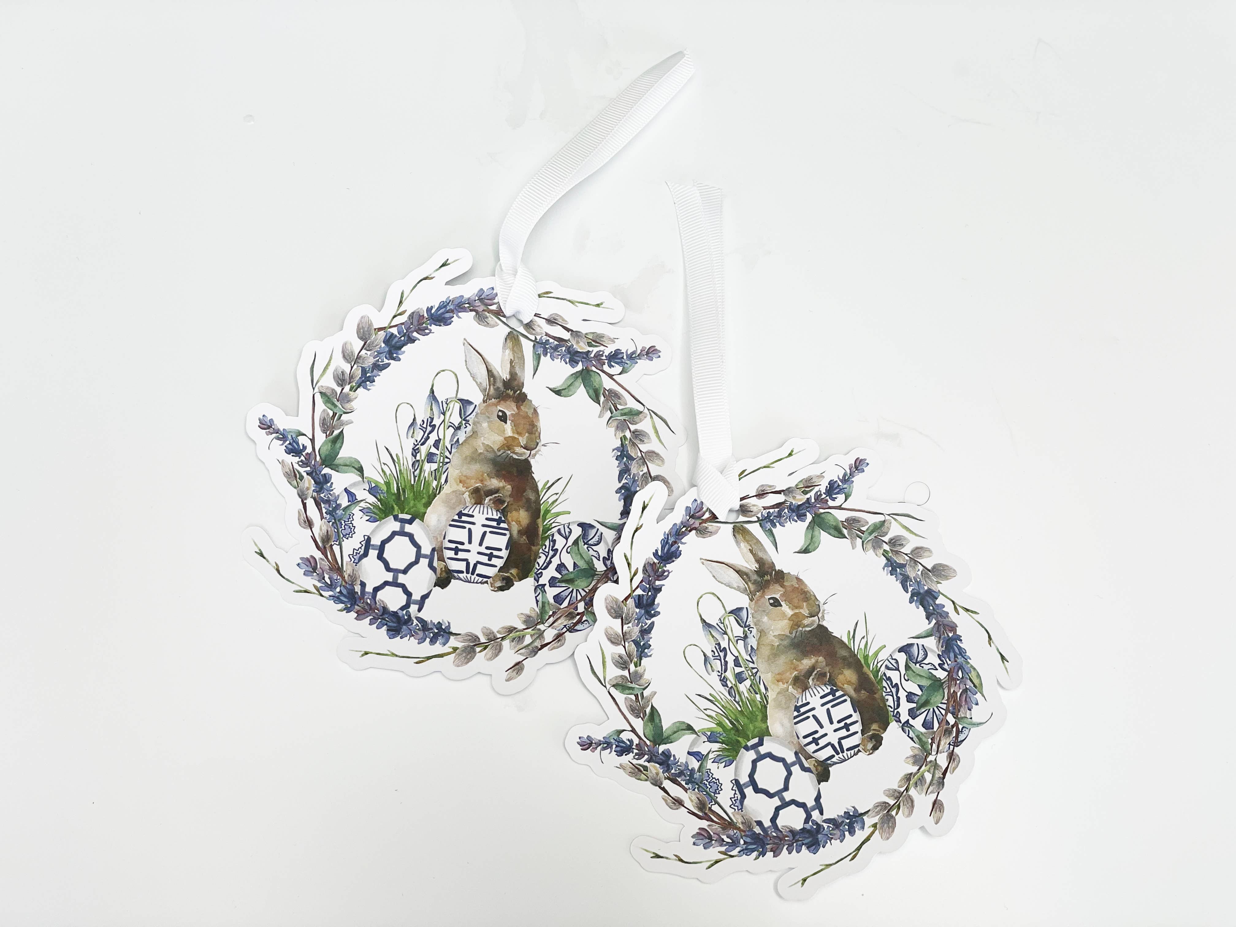 Decorative wreaths with rabbits and floral elements on a white background