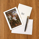 Valentine's Day card with illustration of two men, an envelope, and a pen on a wooden surface.