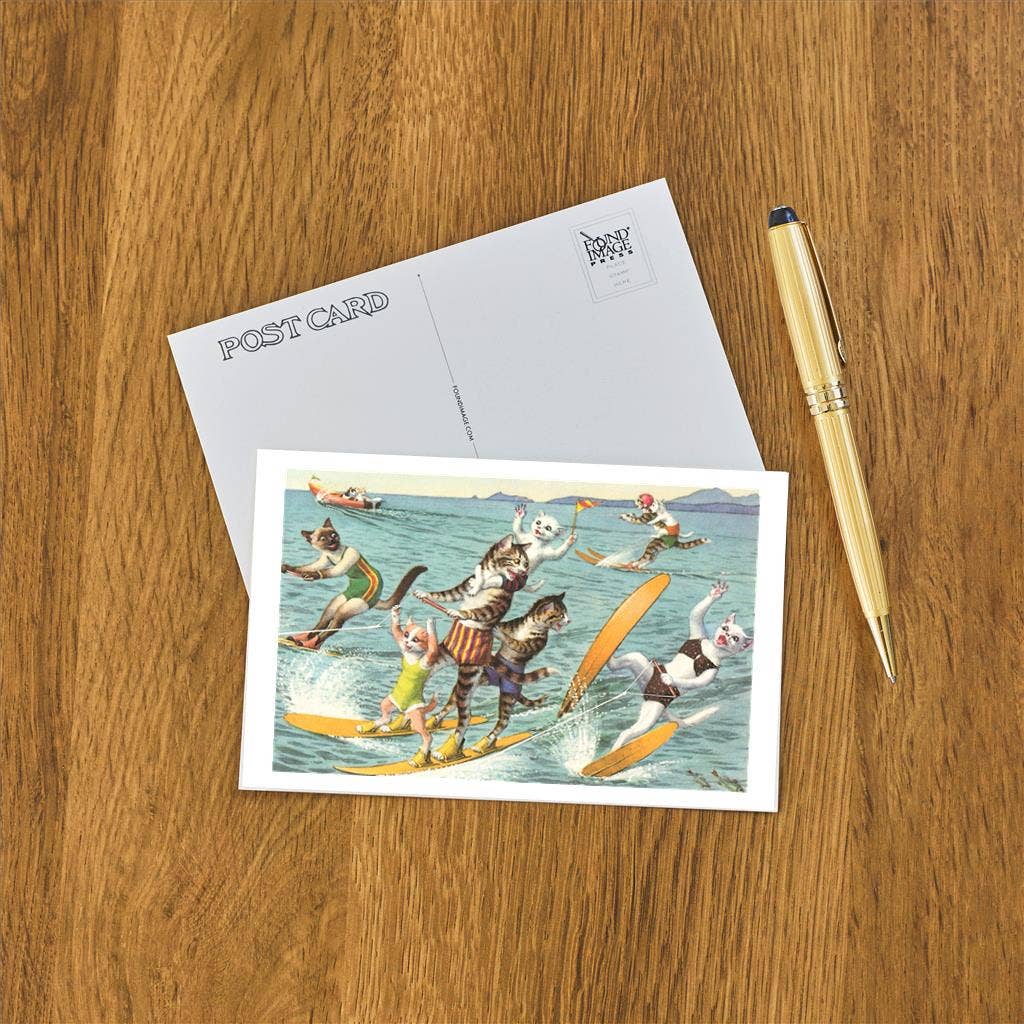 Postcard with cartoon cats surfing on a wooden surface with a pen.