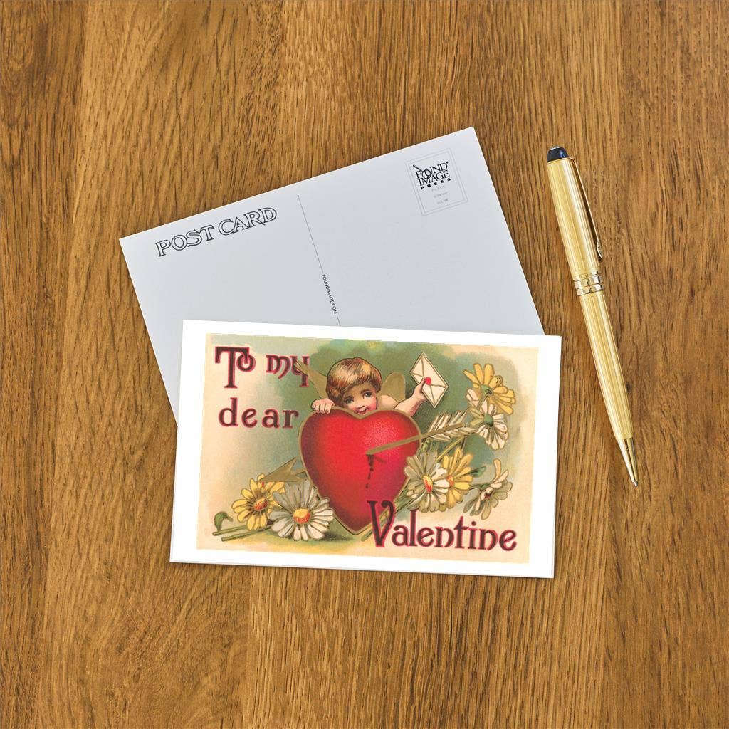 Vintage-style Valentine's Day postcard with a heart and angel illustration on a wooden surface with an envelope and pen.