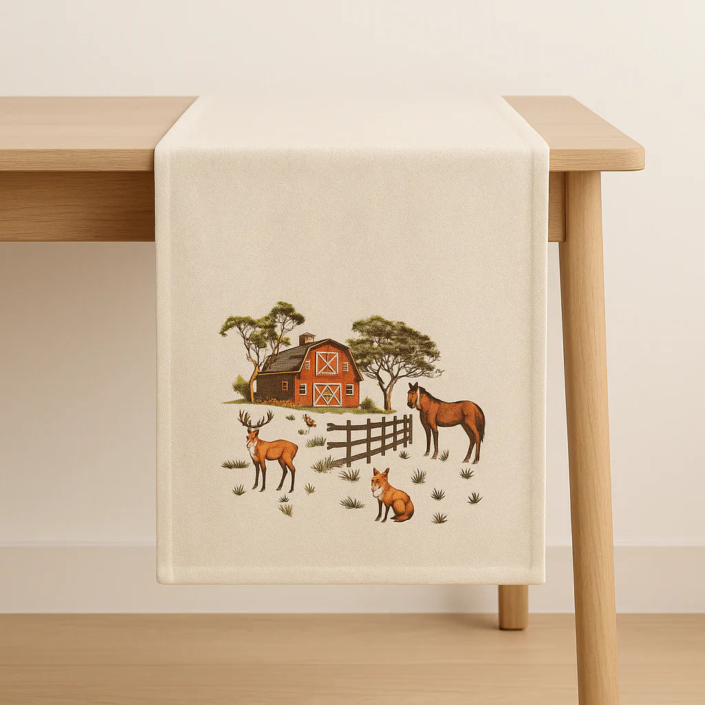 Table runner with farm scene featuring animals and a barn on a wooden table.