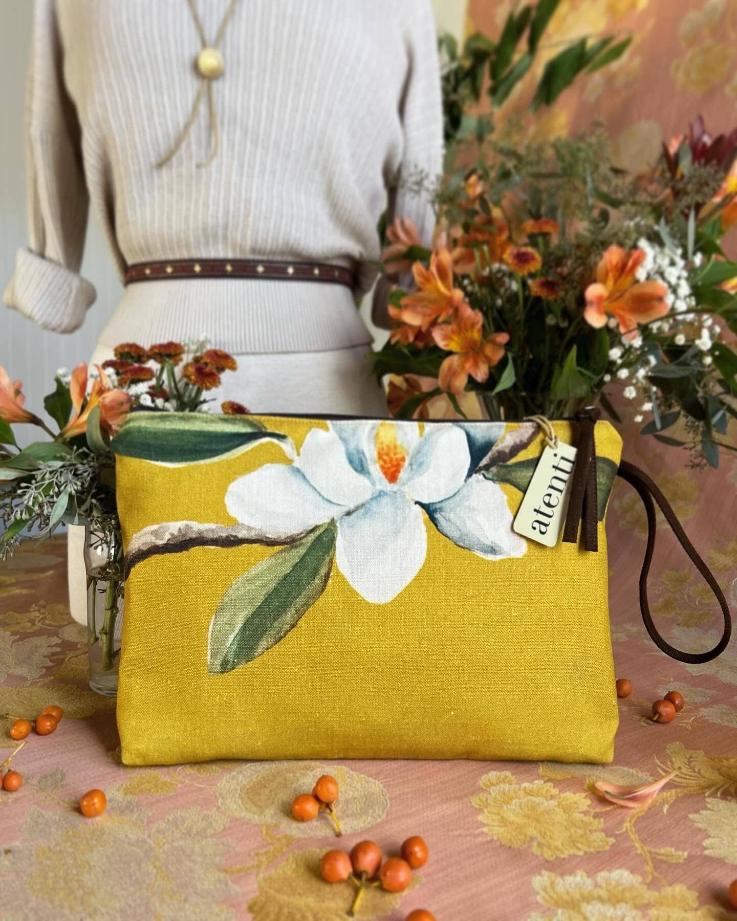 Yellow clutch bag with floral design on a patterned surface