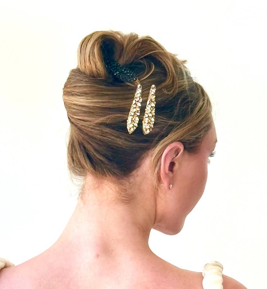 Woman with styled hair featuring a decorative hair clip on a white background