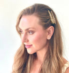 Woman with a gold hair accessory on a plain background