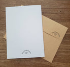 White card and brown envelope with 'Erica DiPaolo Designs' logo on a wooden surface