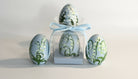 Decorative Easter eggs with floral design in a clear box on a light background