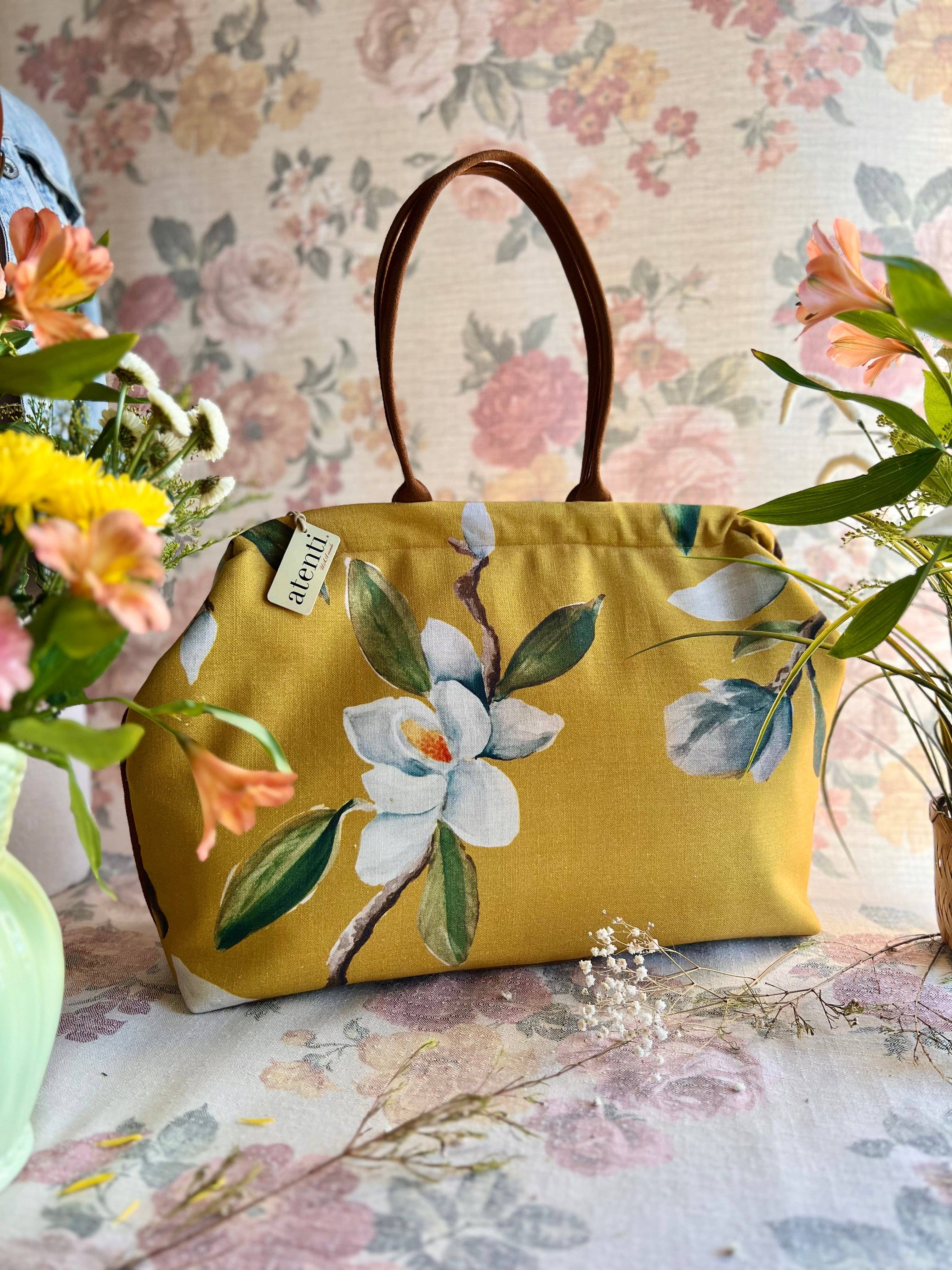 Yellow handbag with floral design on a floral-patterned background