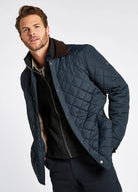 Man wearing a navy quilted jacket on a white background